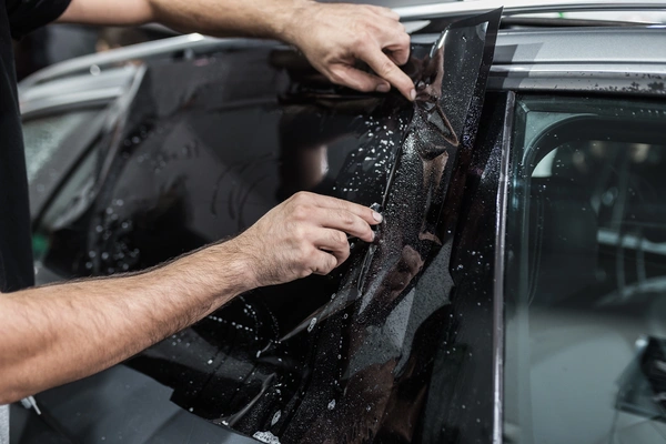 Professional car window tinting with premium film applied